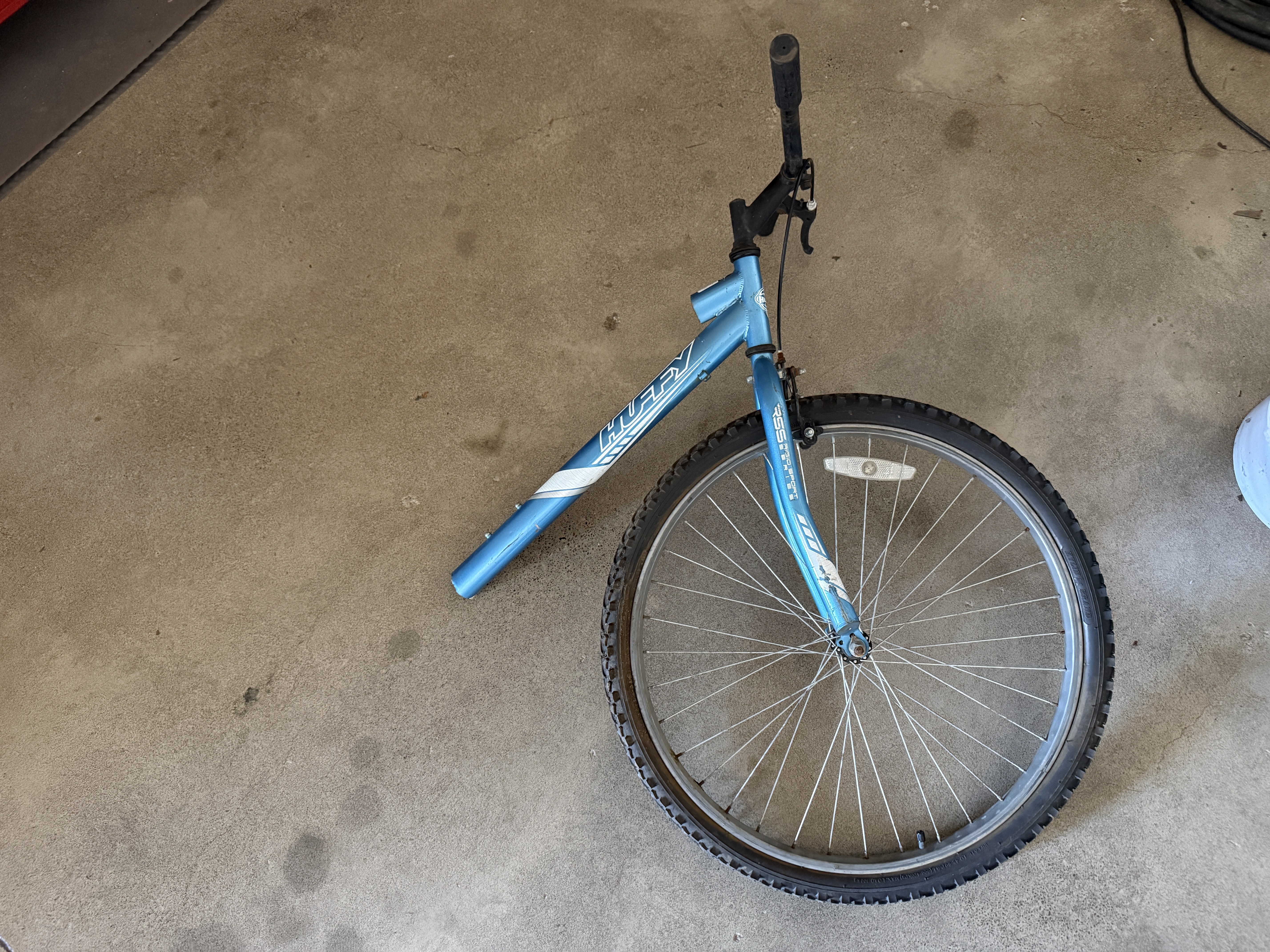 Disassembled bicycle frame and wheel on a shop floor