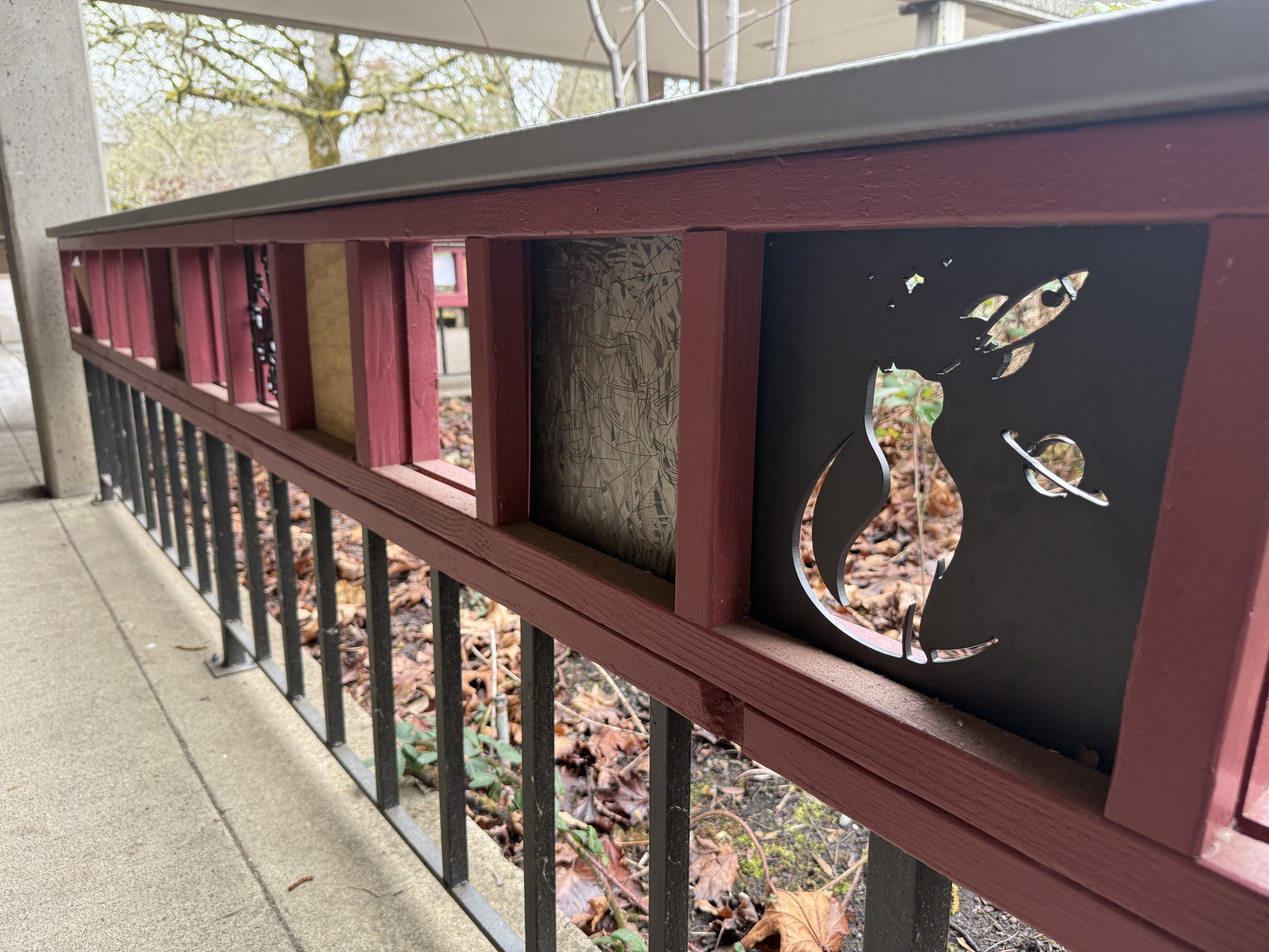 Plasma-cut metal art panels installed in an outdoor school railing