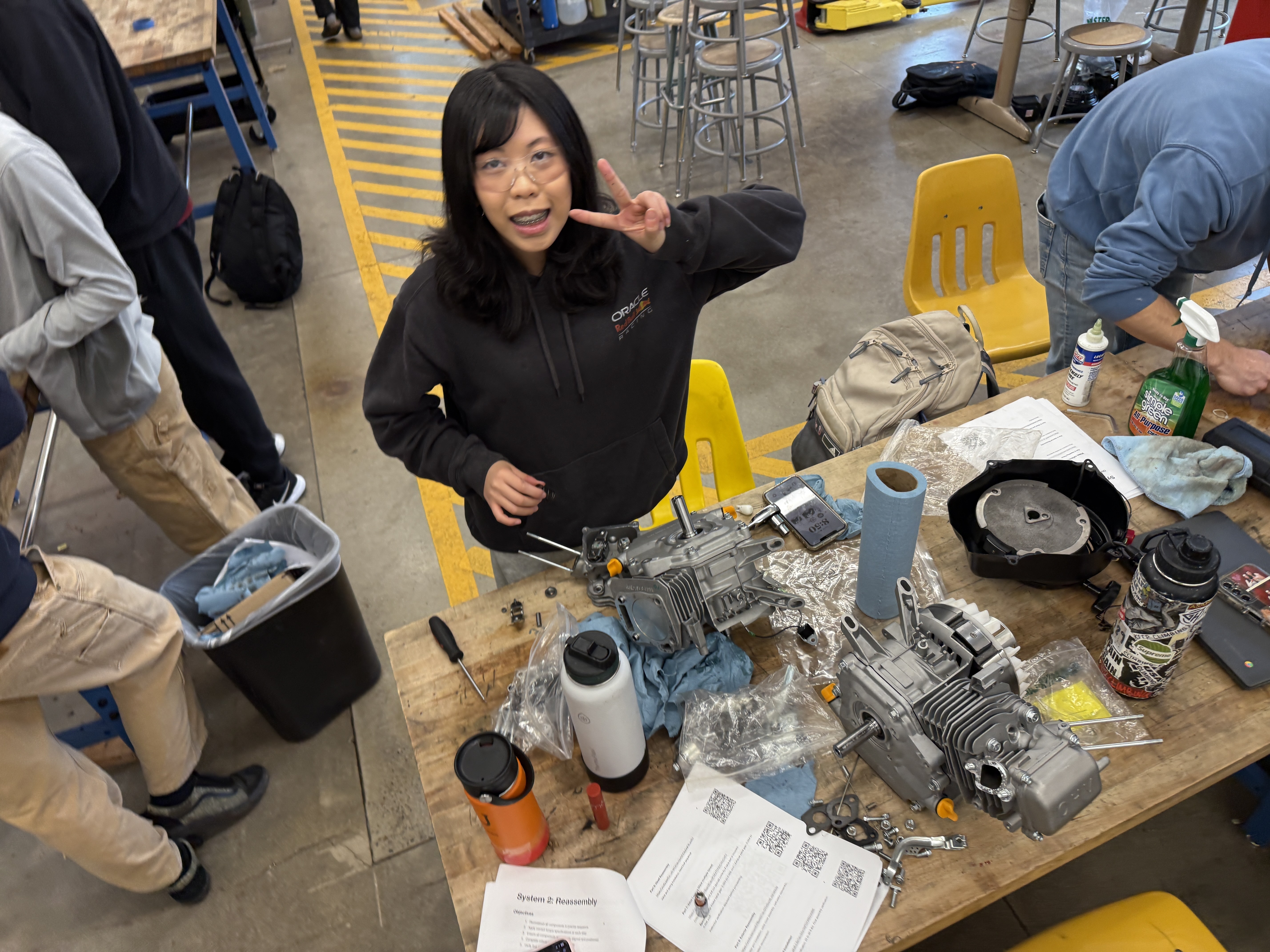 Student at a workbench with a disassembled small engine