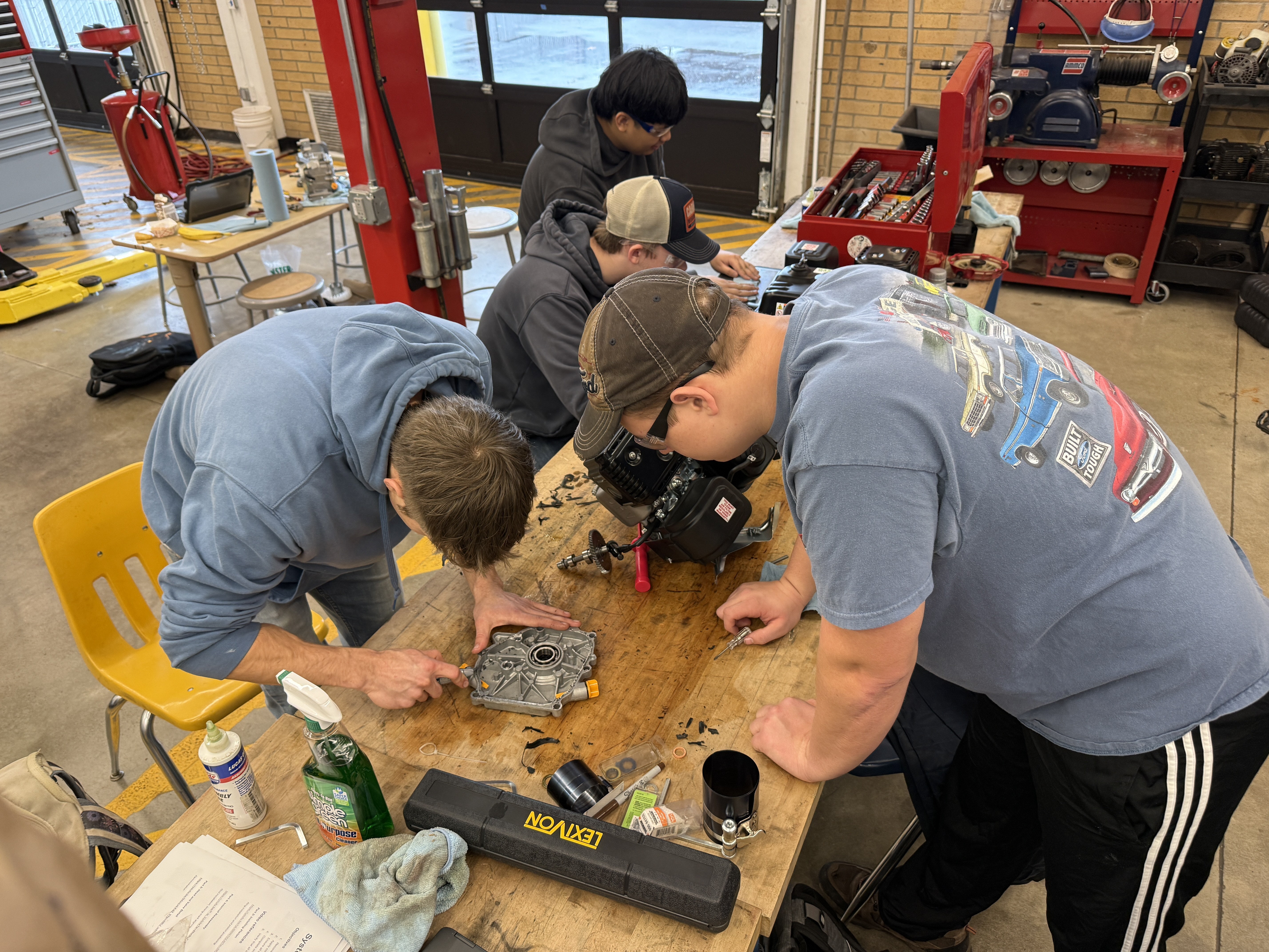 Students collaborating on a small engine teardown